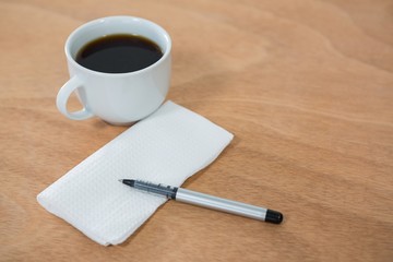 Obraz na płótnie Canvas Black coffee with tissue paper and pen