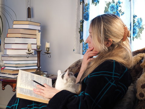 woman reading a book with a pencil at home