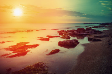 Obrazy na Plexi  Wczesny poranek, wschód słońca nad morzem. Skalisty brzeg morza