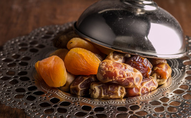 Plate of dates and dried fruits with cover