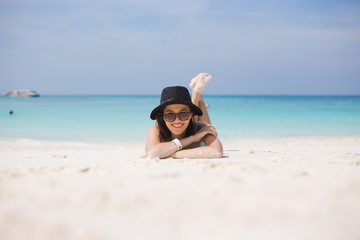 Outdoor summer portrait of young pretty woman sunbathing on the beach, enjoy her freedom and fresh air.