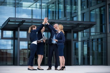 Fototapeta premium Happy businesspeople giving high five to each other