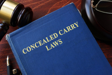 Concealed Carry Laws title on a book and gavel. - obrazy, fototapety, plakaty