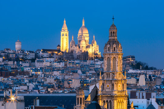 Fototapeta Aerial view of Sacre-Coeur Basilica or Basilica of the Sacred Heart of Jesus at the butte Montmartre and Saint Trinity church at night, Paris, France