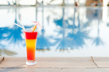 Colored cocktails on a background of water. Colorful cocktails near the pool. Beach party. Summer drinks. Exotic drinks. Glasses of cocktails on table near pool. Summer drinks photo concept. Сocktail