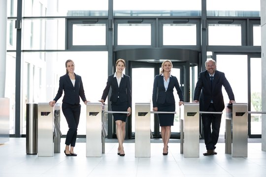 Businesspeople Standing At Turnstile Gate