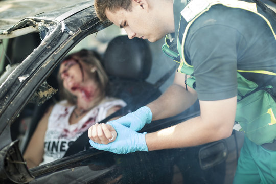 Paramedic helping car crash victim after accident