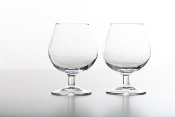 Two empty cognac glasses on white background