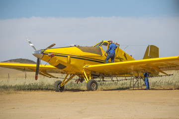 Mechanics preparing yellow crop dusting plane