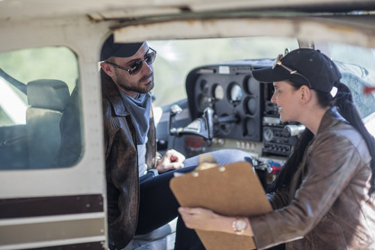 Two Young Pilots Inspecting A Light Aircraft