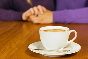 Loving young couple sitting in the cafeteria, talking and smiling. Drink hot coffee.