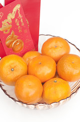 Happy Chinese New Year 2017 the year of the rooster with prosperity Mandarines oranges in glass bowl with golden coins and green leaves red envelope for healthy and wealthy fortune year of rooster