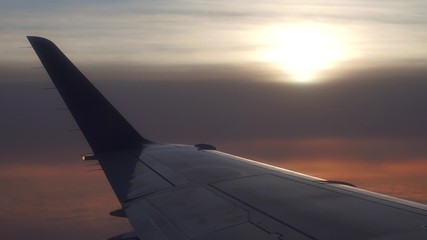 Fototapeta na wymiar Edge of airliner wing against cloudy sunset