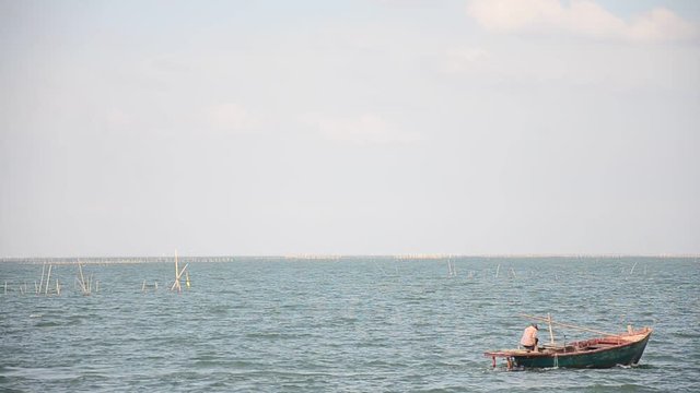 Thai people riding fishing motor boat go to pier in andaman sea at Bangsan beach after catch fish in Chonburi, Thailand