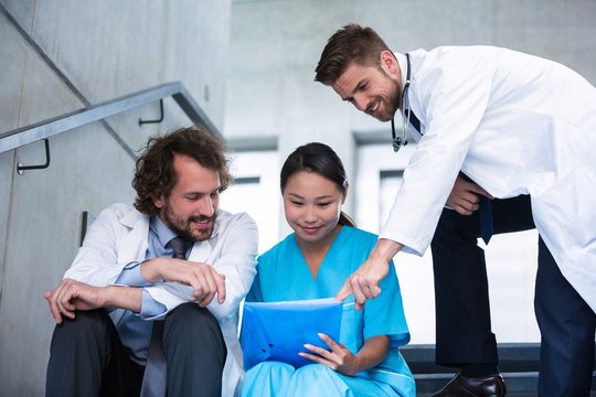 Doctors and nurse discussing over a report
