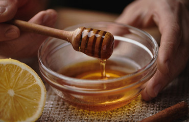 Natural cold remedy. Macro shot of honey stick and lemon.    