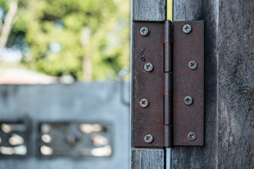 Close up of rusty hinge on the old wooden door