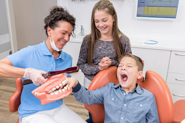 Zahnärztin macht Spaß mit zwei Kindern in der Praxis