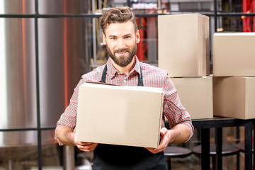 Portrait of professional courier with boxes delivering packages at the manufacturing.