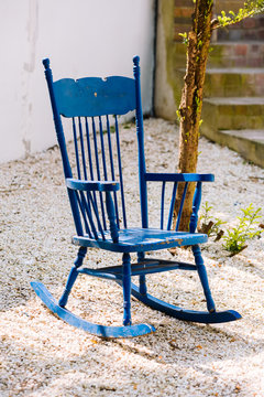 Blue antique rocking chairs on stone porch welcome visitors to sit and relax for a while