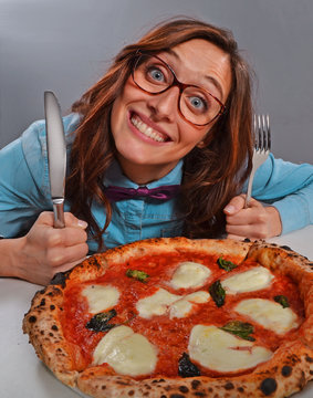 Mujer nerd con anteojos comiendo pizza.