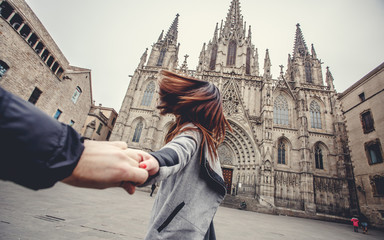 Lovers couple holding hands in a Cathedral Holy Cross and Saint Eulalia. Europa, Barselona, Spain. Old Building in Barcelona, Spain - obrazy, fototapety, plakaty