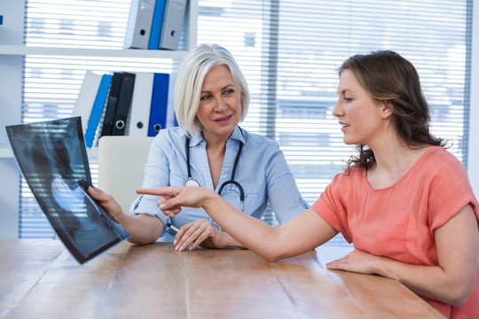 Female doctor explaining x-ray report to patient