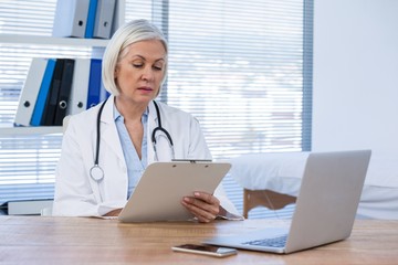 Female doctor looking at clipboard