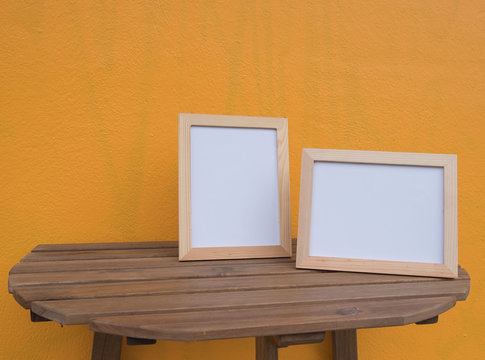 Two photo Frame on a wooden on Yellow background .