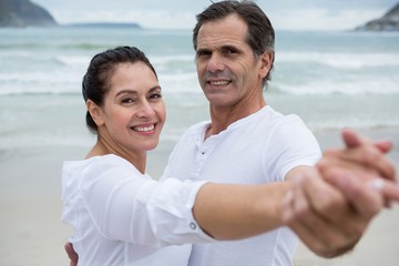 Obraz premium Portrait of romantic couple dancing on beach