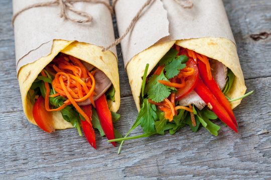 Various of tasty tortilla wraps on a wooden background. Healthy street food