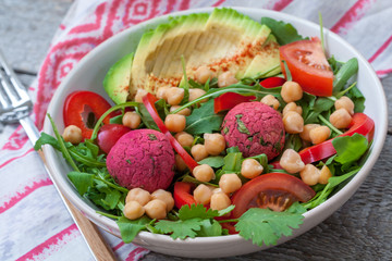 Vegan salad with falafel and vegetables. View top on dark wooden background. Vegan Food Concept.