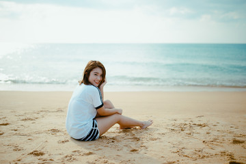 Fototapeta na wymiar Bueatiful girl sit on the beach.