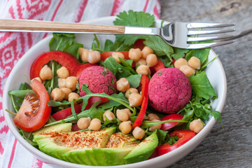 Vegan salad with falafel and vegetables. View top on dark wooden background. Vegan Food Concept.