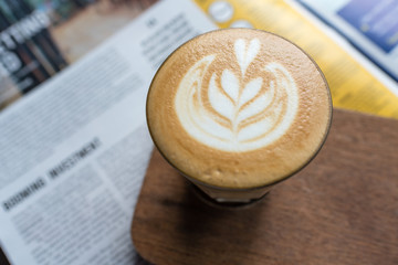 cafe latte on a wooden table with heart shape latte art