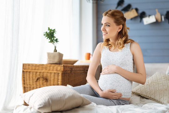 Pregnant woman sitting in a bedroom