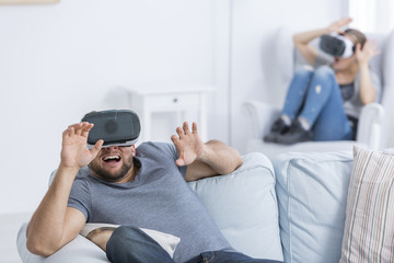 Young couple using VR goggles