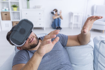 Man sitting on sofa with VR glasses