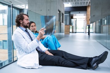Stressed doctor and nurse sitting on floor