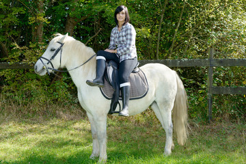 young beautiful brunette woman riding horse