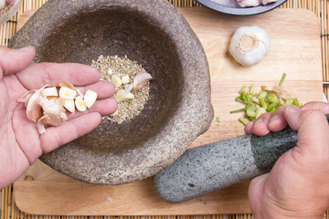 Chef putting garlic to mortar