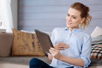 Obraz premium Pregnant woman using tablet in her room