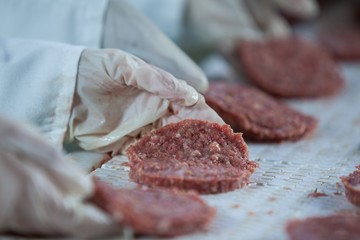 Butchers processing hamburger patty