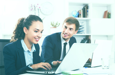 Business colleagues sitting with laptops