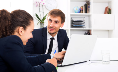 Business male assistant wearing formalwear using laptop