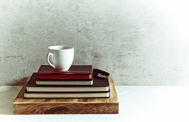 A cup of coffee on black notebooks
