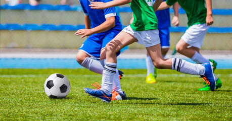 Young Boys Kicking Football on the Sports Field