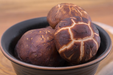 Shiitake mushroom in a black bowl.