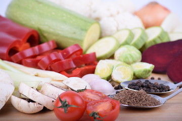 Vegetables and grains on spoons served on a wooden board close up