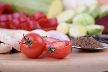 Tomatoes on a wooden board with vegetables close up